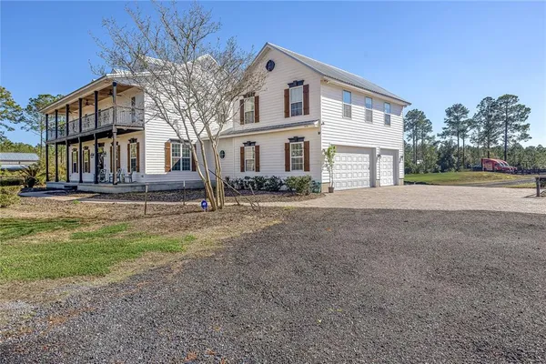 an aerial view of a house with swimming pool and large trees
