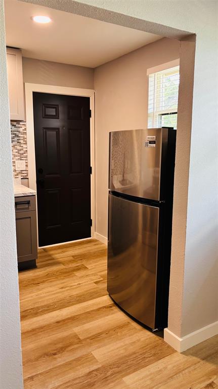 4603 Junius Street, Unit 4 Dallas, TX 75246 - Photo 5 of 14 a view of a refrigerator in kitchen and wooden floor
