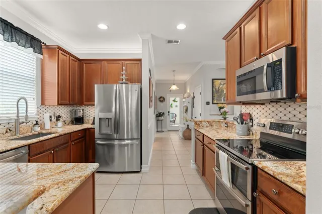 a kitchen with stainless steel appliances granite countertop a refrigerator stove and sink