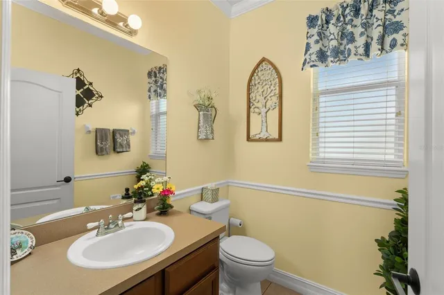 a bathroom with a sink a mirror a toilet and a window