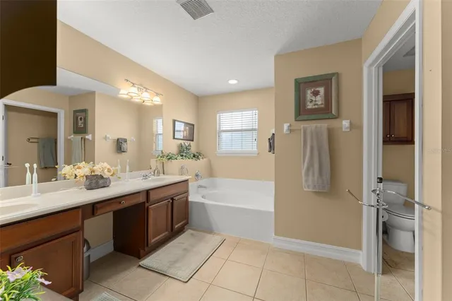 a spacious bathroom with a bathtub sink and mirror