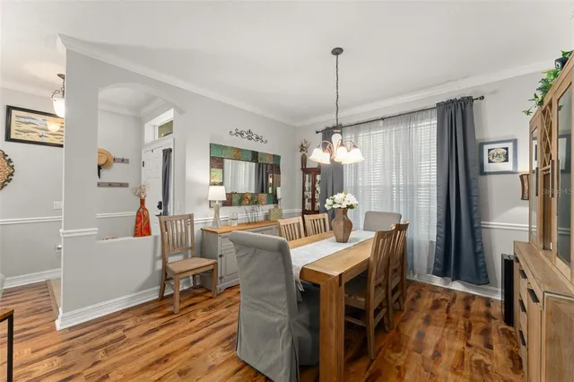 a view of a dining room and livingroom with furniture wooden floor a chandelier