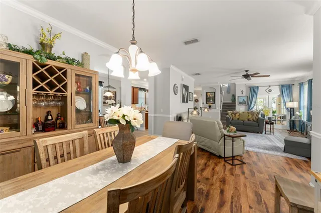 a view of a dining room and livingroom with furniture wooden floor a chandelier