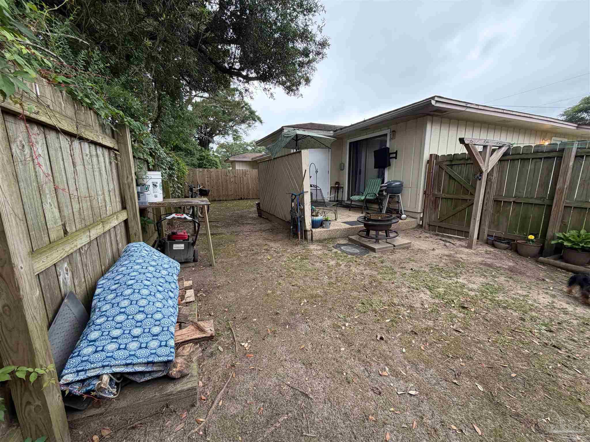 130 East 9 Mile Road Pensacola, FL 32534 - Photo 21 of 25 a backyard of a house with barbeque oven table and chairs
