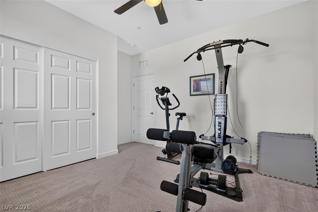 1824 Redland Ridge Street Henderson, NV 89002 - Photo 51 of 69 A well-lit exercise room, featuring soft carpeting and clean white doors, offers a versatile space for fitness.