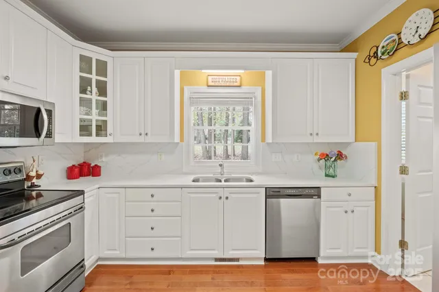 a kitchen with white cabinets stainless steel appliances and sink