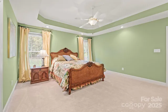 a spacious bedroom with a bed and a chandelier