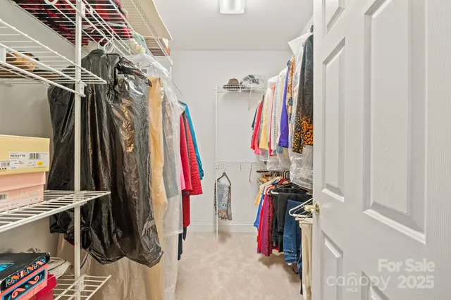 a view of walk in closet with clothes