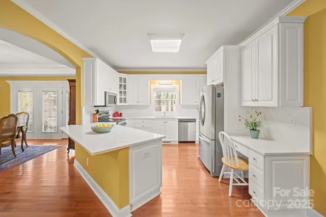 a large kitchen with a table chairs refrigerator and cabinets