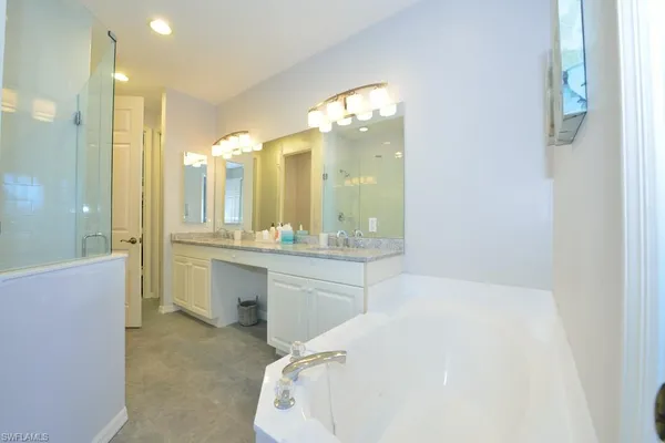 a spacious bathroom with a double vanity sink mirror and shower