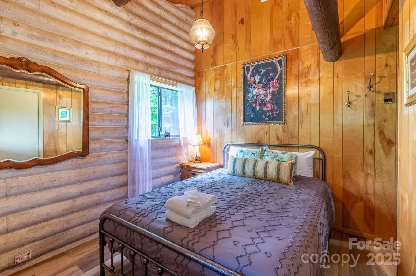1491 Battle Branch Road Bryson City, NC 28713 - Photo 14 of 34 a bedroom with a bed and wooden floor