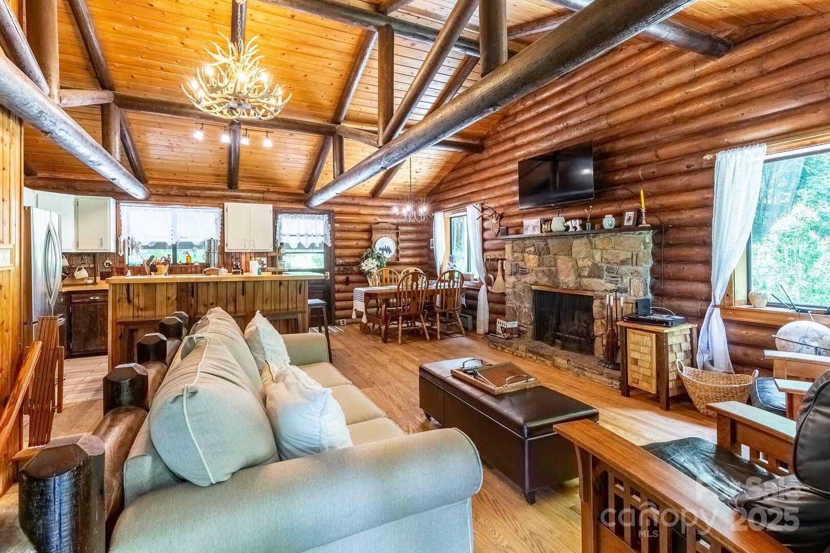 1491 Battle Branch Road Bryson City, NC 28713 - Photo 3 of 34 a living room with furniture a fireplace a flat screen tv and windows