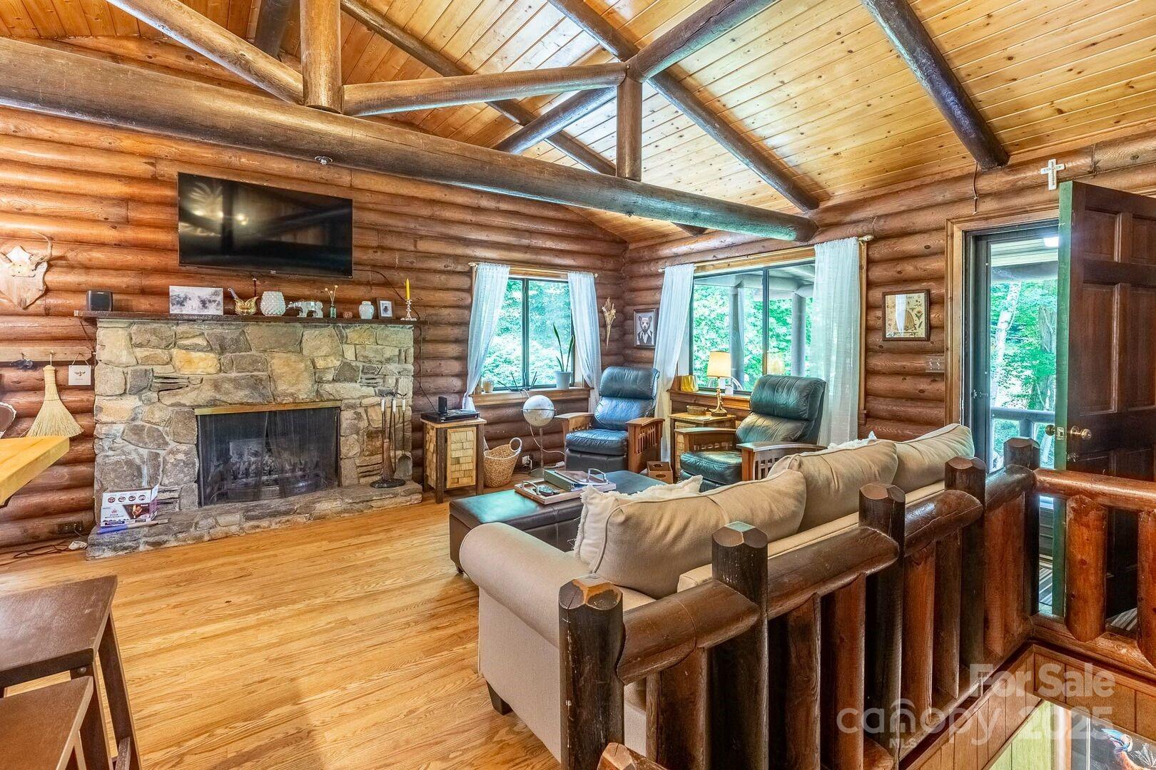 1491 Battle Branch Road Bryson City, NC 28713 - Photo 5 of 34 a living room with furniture a fireplace and a floor to ceiling window