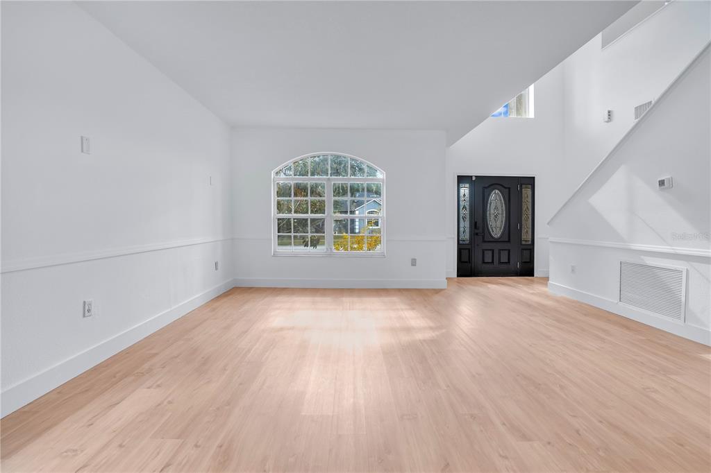 444 Acacia Tree Way Kissimmee, FL 34758 - Photo 4 of 38 a view of an empty room with a window and wooden floor