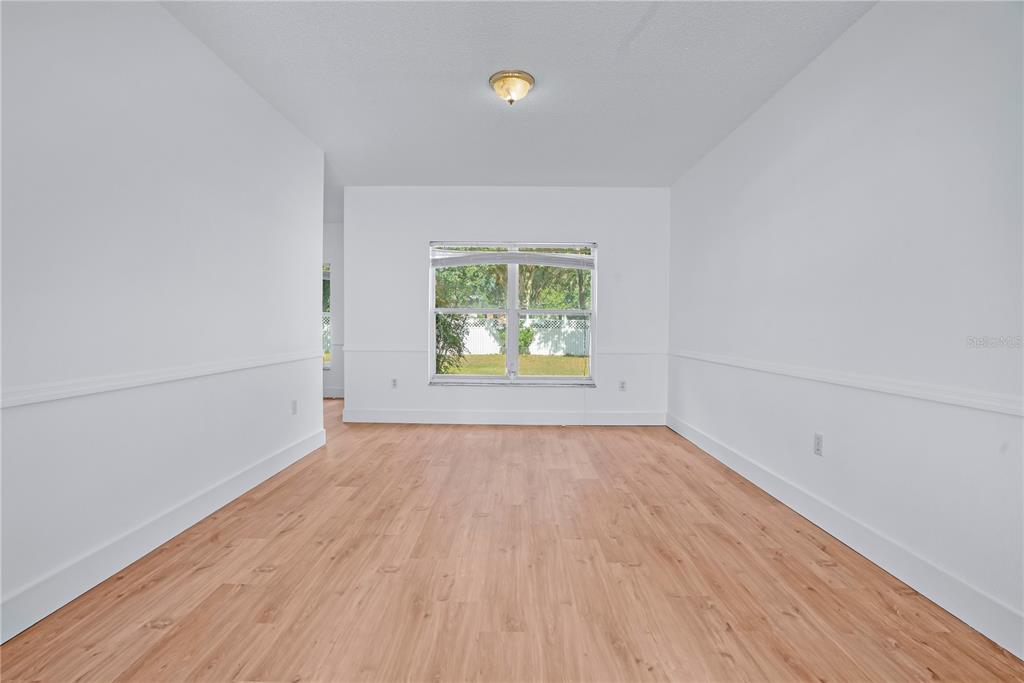 444 Acacia Tree Way Kissimmee, FL 34758 - Photo 8 of 38 an empty room with wooden floor and windows