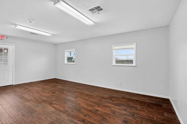 a view of a kitchen with wooden floor and windows