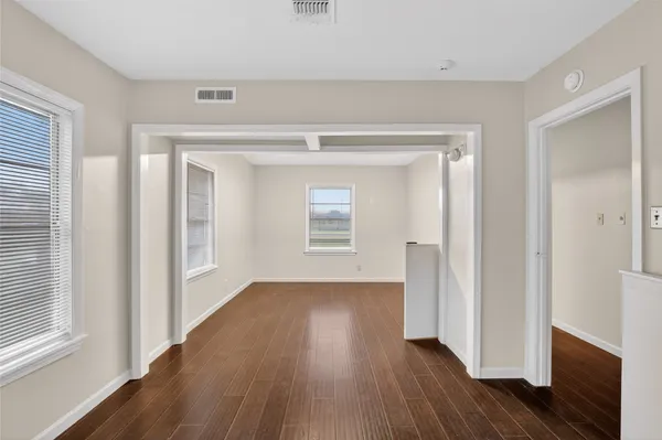 a view of a kitchen with a fridge wooden floor and a window