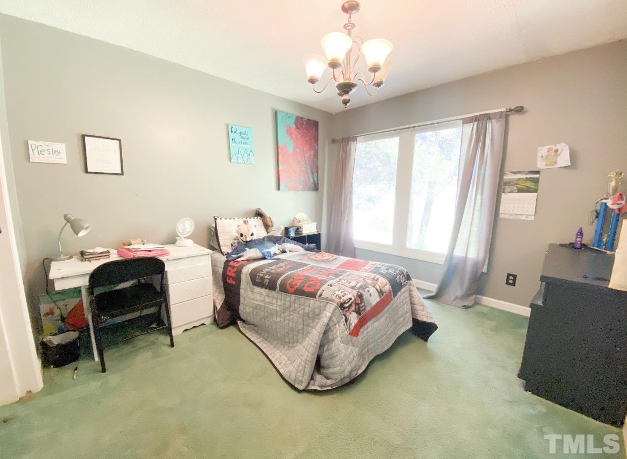 105 Lawson Farm Road Roxboro, NC 27574 - Photo 13 of 25 a bedroom with a bed and a chandelier