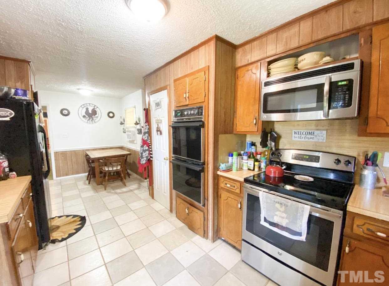 105 Lawson Farm Road Roxboro, NC 27574 - Photo 8 of 25 a kitchen with stainless steel appliances a stove a microwave and a refrigerator