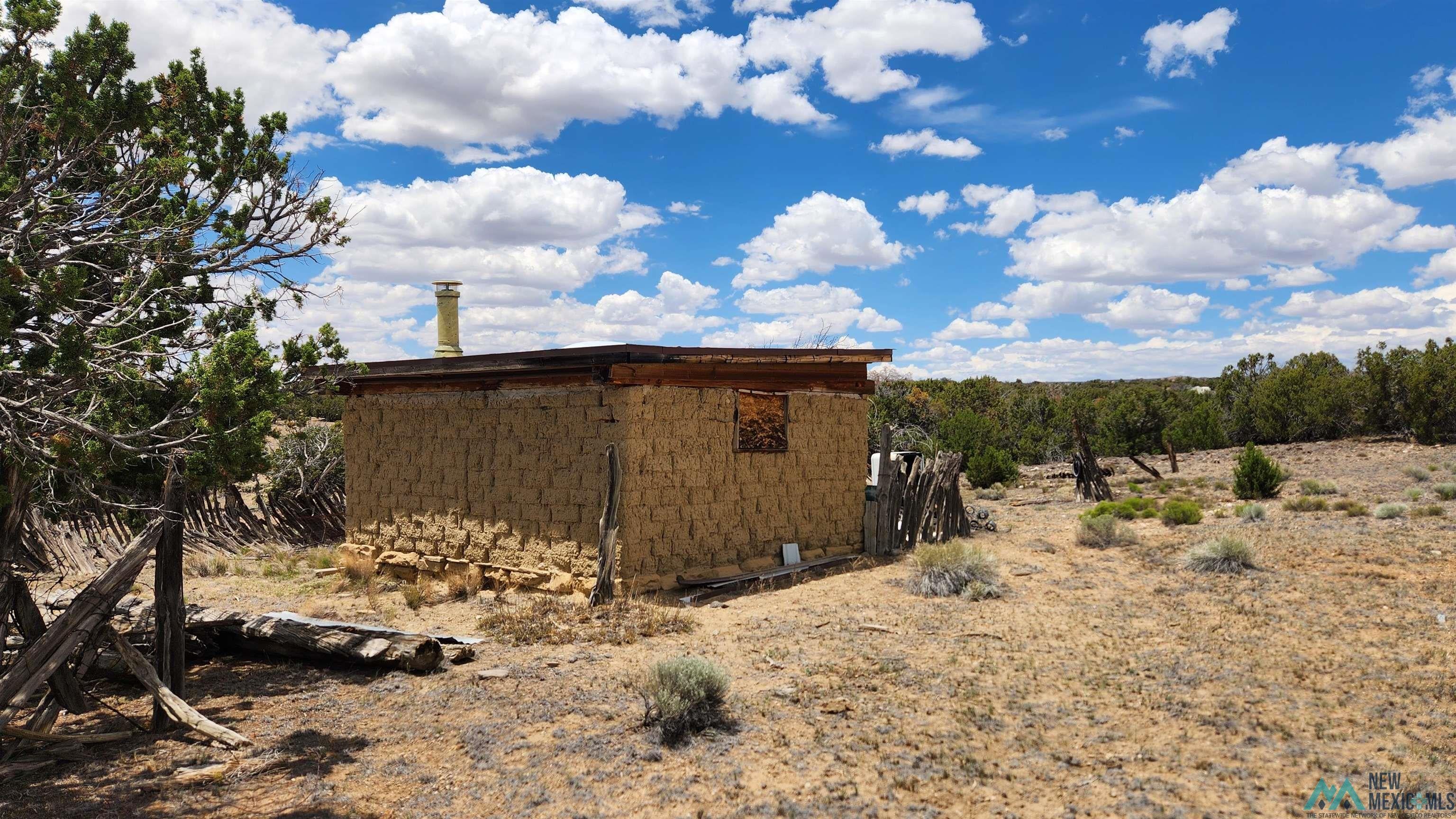 31 Henderson Road Quemado, NM 87829 - Photo 32 of 35 Adobe-style structure featuring natural earth tones and a flat roofline