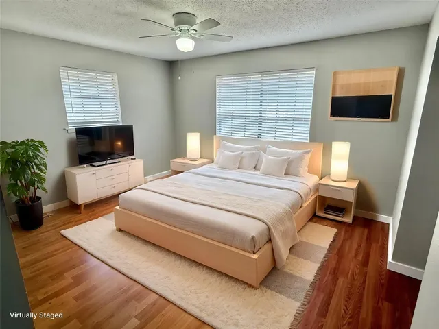 a bedroom with a large bed a flat tv screen and a fireplace
