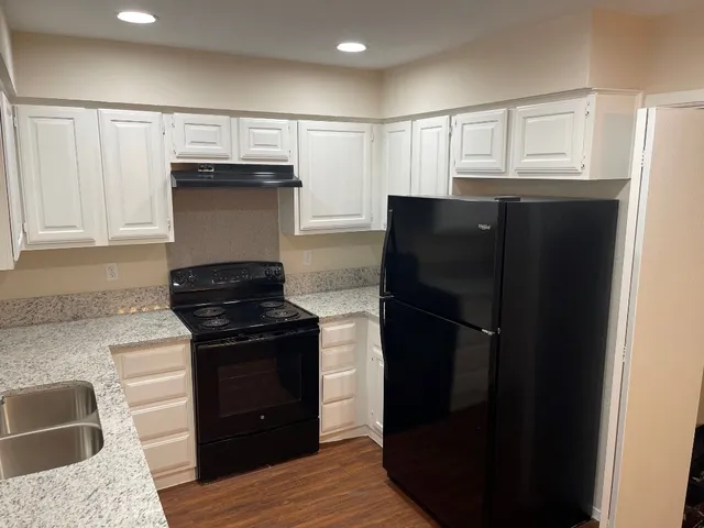 a kitchen with a refrigerator and a stove top oven