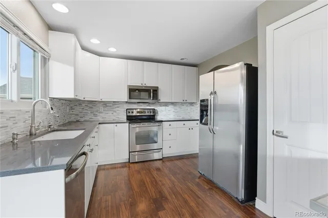 a kitchen with a refrigerator sink and wooden floor