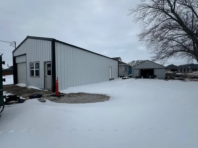 a backyard of a house with fire pit and trees