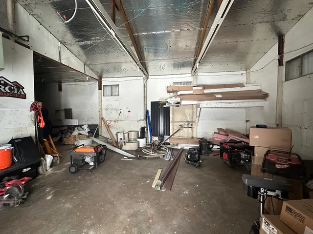 a view of a garage with cars and other equipment