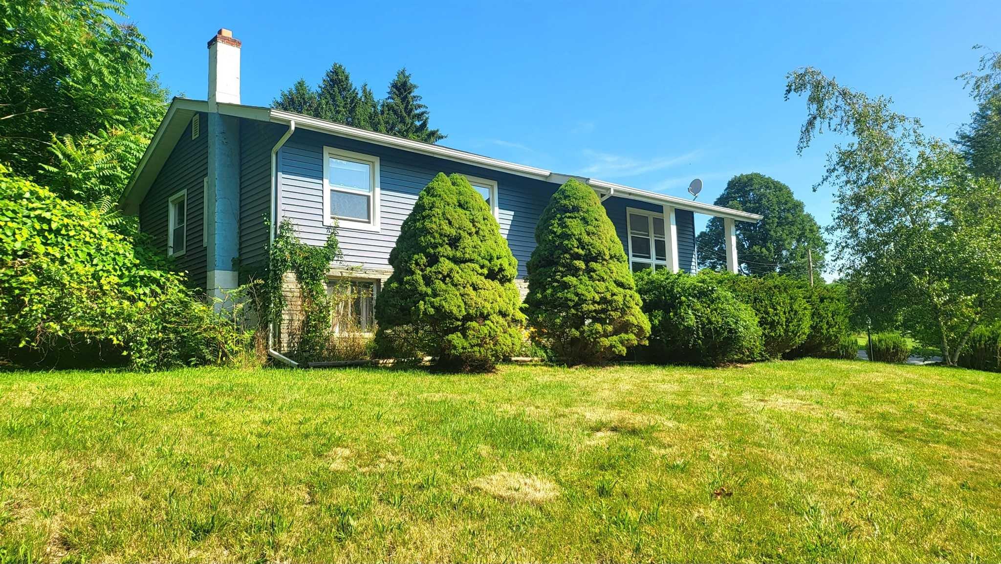 a front view of house with yard and green space