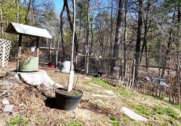 a view of a patio with table and chairs potted plants and large tree