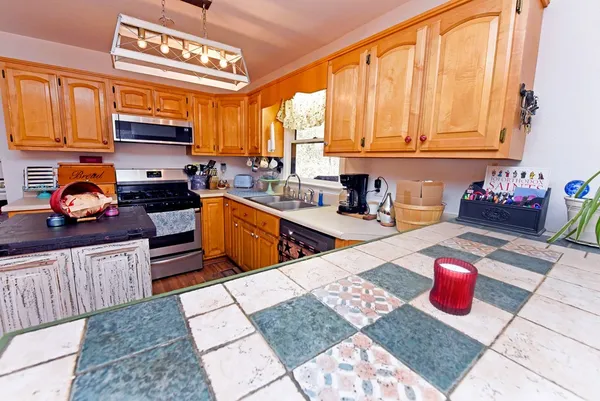 a kitchen with stainless steel appliances kitchen island granite countertop a sink dishwasher stove and cabinets