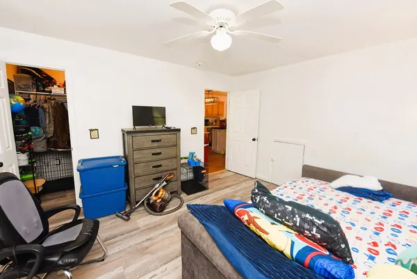 a bedroom with a bed and a flat tv screen on dresser