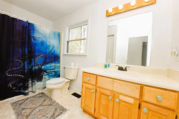 a bathroom with a granite countertop toilet sink and mirror