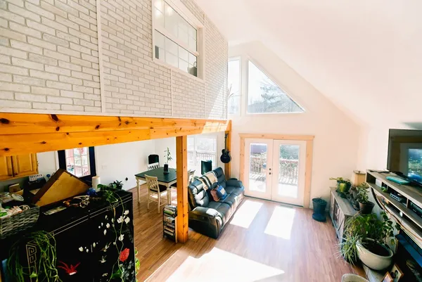 a living room with furniture a flat screen tv and a floor to ceiling window