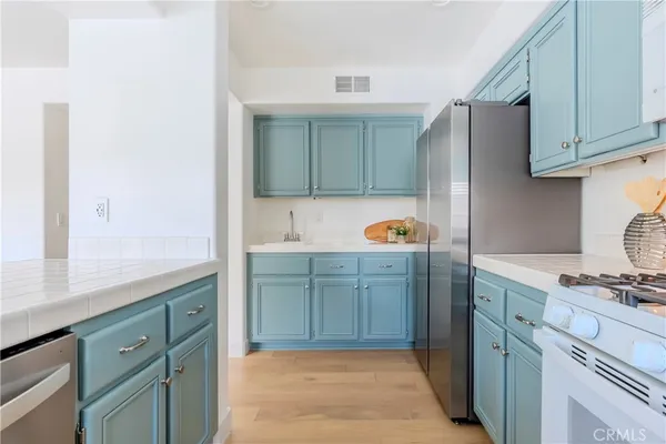 a kitchen with stainless steel appliances granite countertop a refrigerator and a sink