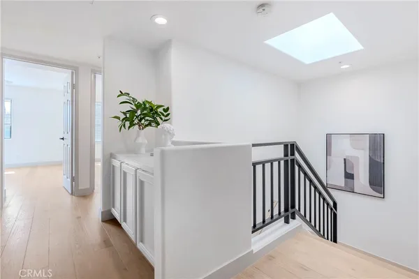 a view of a hallway with wooden floor and staircase