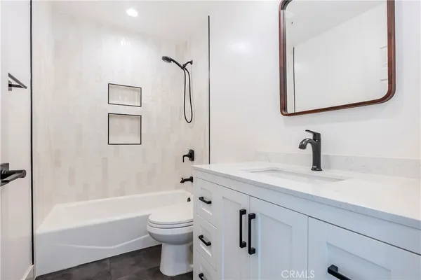 a bathroom with a toilet a sink a mirror and shower