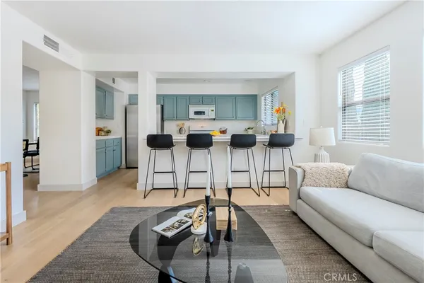 a living room with furniture a large window and a wooden floor