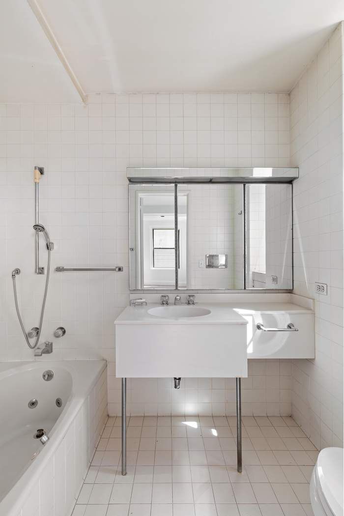 920 5th Avenue, Unit 10B Manhattan, NY 10021 - Photo 19 of 23 a bathroom with a tub sink and mirror