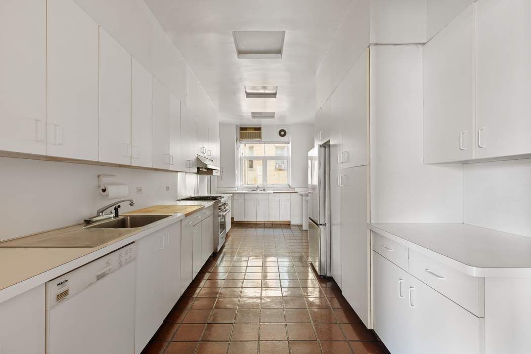 920 5th Avenue, Unit 10B Manhattan, NY 10021 - Photo 10 of 23 a large white kitchen with granite countertop a sink
