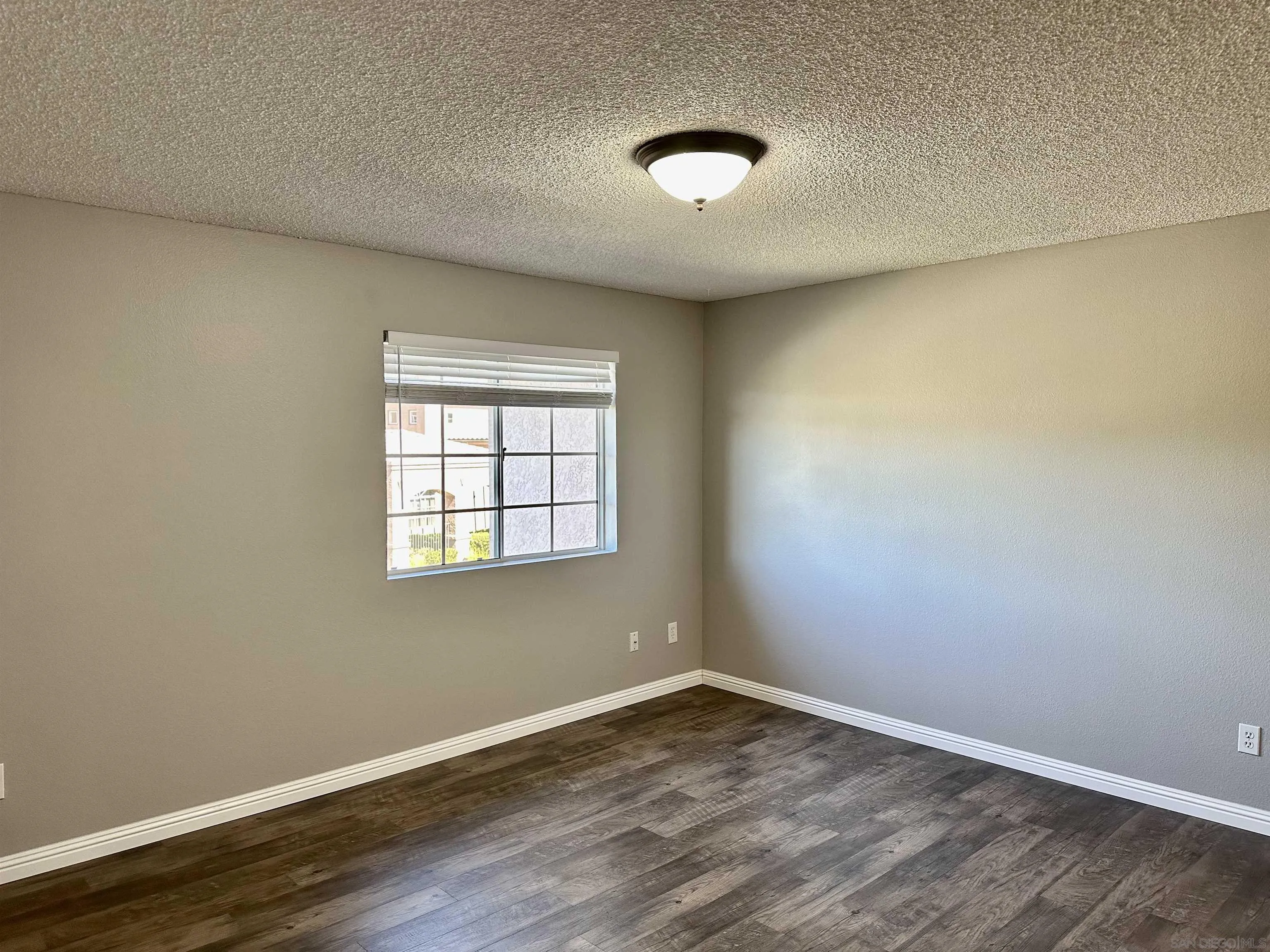 17161 Alva Road, Unit 123 San Diego, CA 92127 - Photo 22 of 30 an empty room with wooden floor and windows