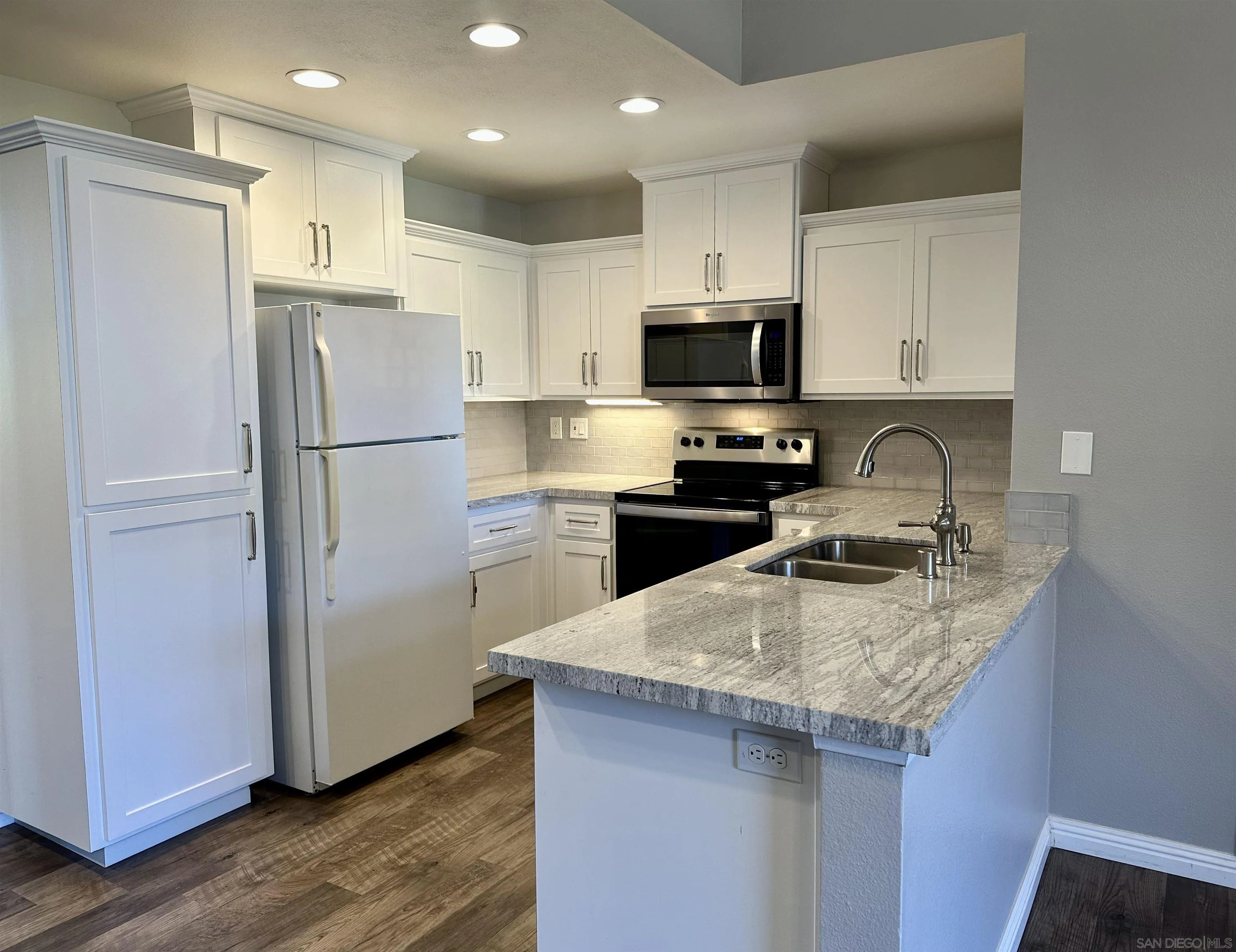 17161 Alva Road, Unit 123 San Diego, CA 92127 - Photo 6 of 30 a kitchen with a refrigerator a sink a stove a microwave and cabinets