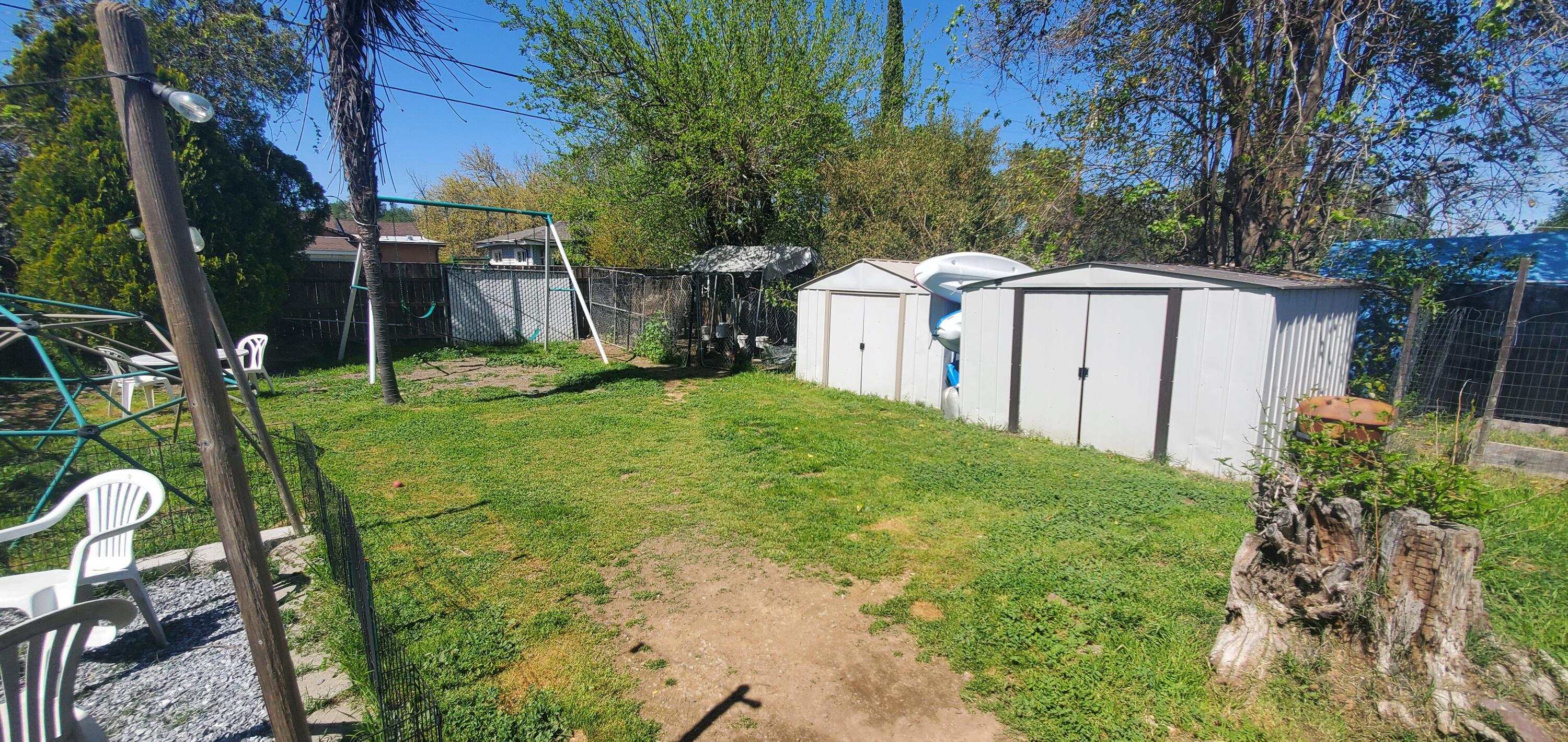 19368 Lucille Street Anderson, CA 96007 - Photo 9 of 13 a backyard of a house with table and chairs and wooden fence