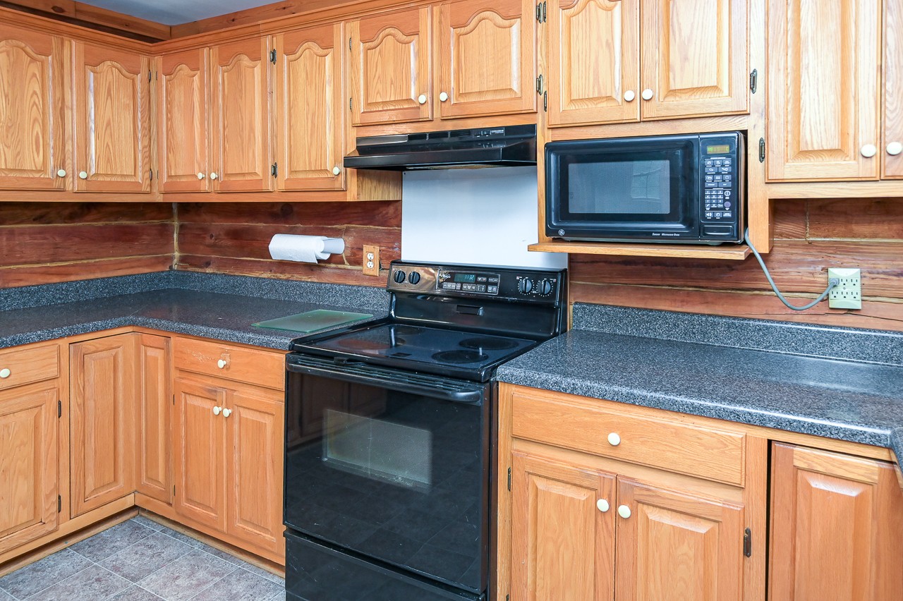 855 Hickory Drive Pulaski, TN 38478 - Photo 12 of 57 a kitchen with granite countertop white cabinets and black appliances