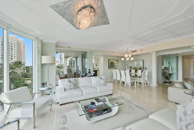 a kitchen with white cabinets a sink dishwasher a stove and a dining table with wooden floor