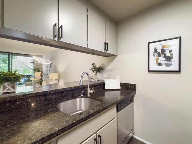a kitchen with granite countertop a sink and cabinets
