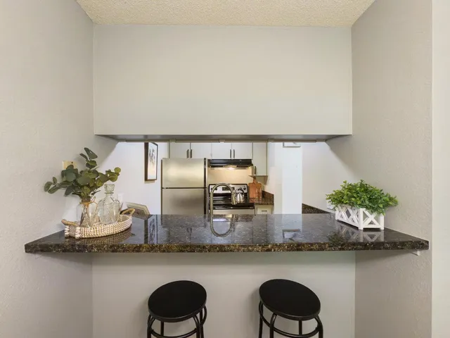a kitchen with two chairs and a vase of flowers on it