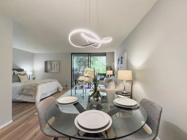 a view of a dining room with furniture a chandelier and wooden floor