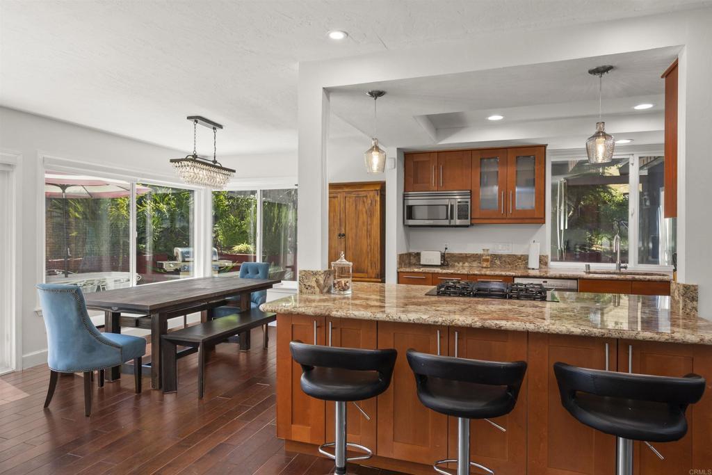3099 Driscoll Drive San Diego, CA 92117 - Photo 17 of 41 a kitchen with stainless steel appliances granite countertop a kitchen island a table and chairs in it